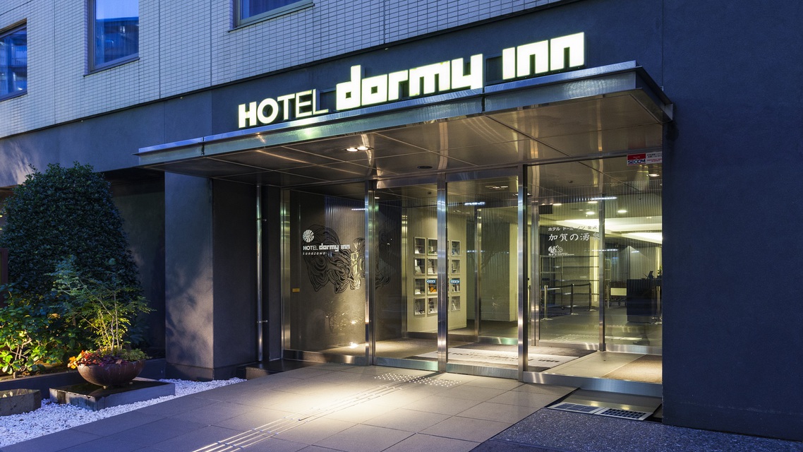 天然温泉 加賀の湧泉 ドーミーイン金沢の入口。夜、dormy innの看板が光っている
