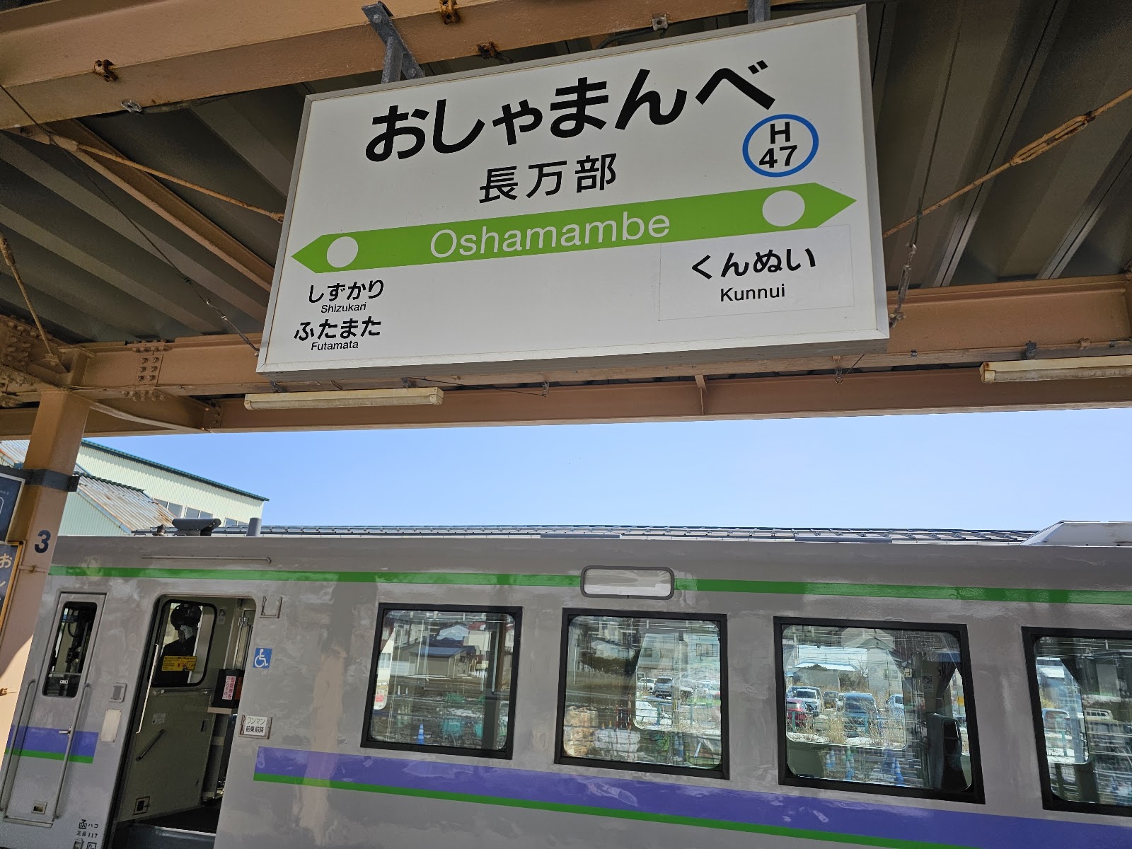 おしゃまんべ駅の駅名標と列車